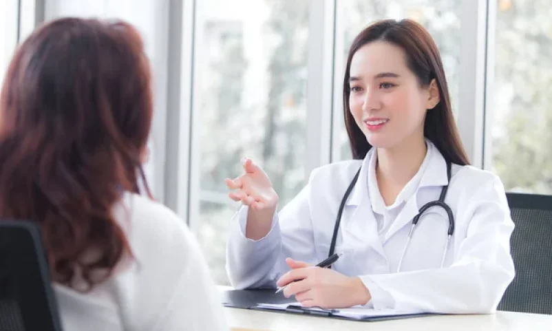 Female doctor discussing Well-Woman Health Screening results with patient in Singapore clinic.